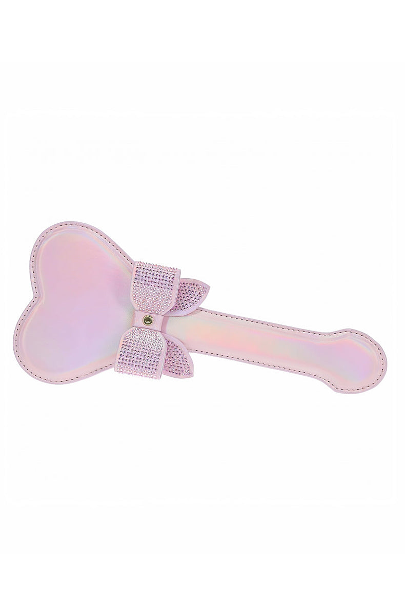 Side view of the pink iridescent heart paddle showing the rhinestone bow in profile and stitched edge along the handle.