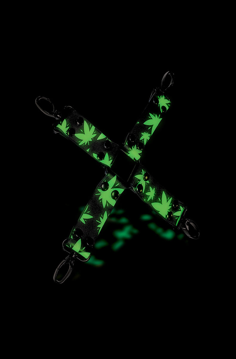 Close-up of cannabis-leaf print on black faux leather arm of hogtie connector with black snap clip at the end.