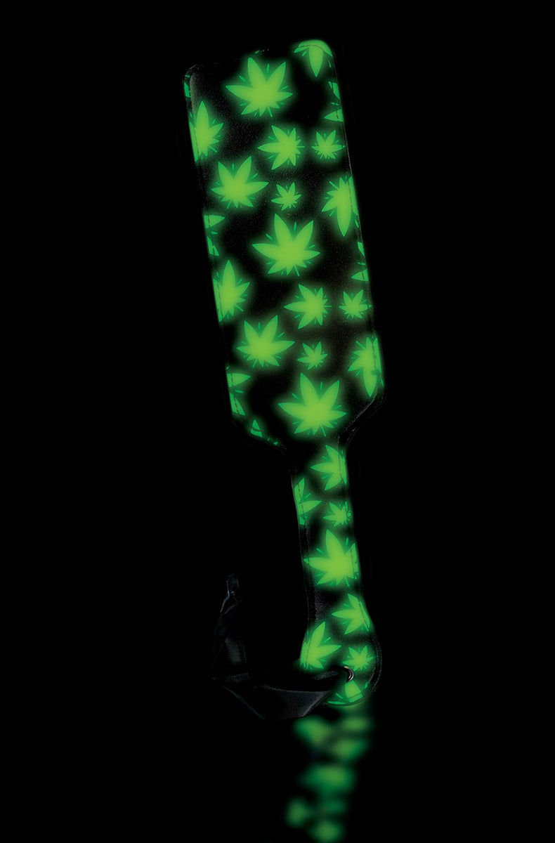 Front view of the cannabis-leaf paddle glowing bright green against a pure black background.