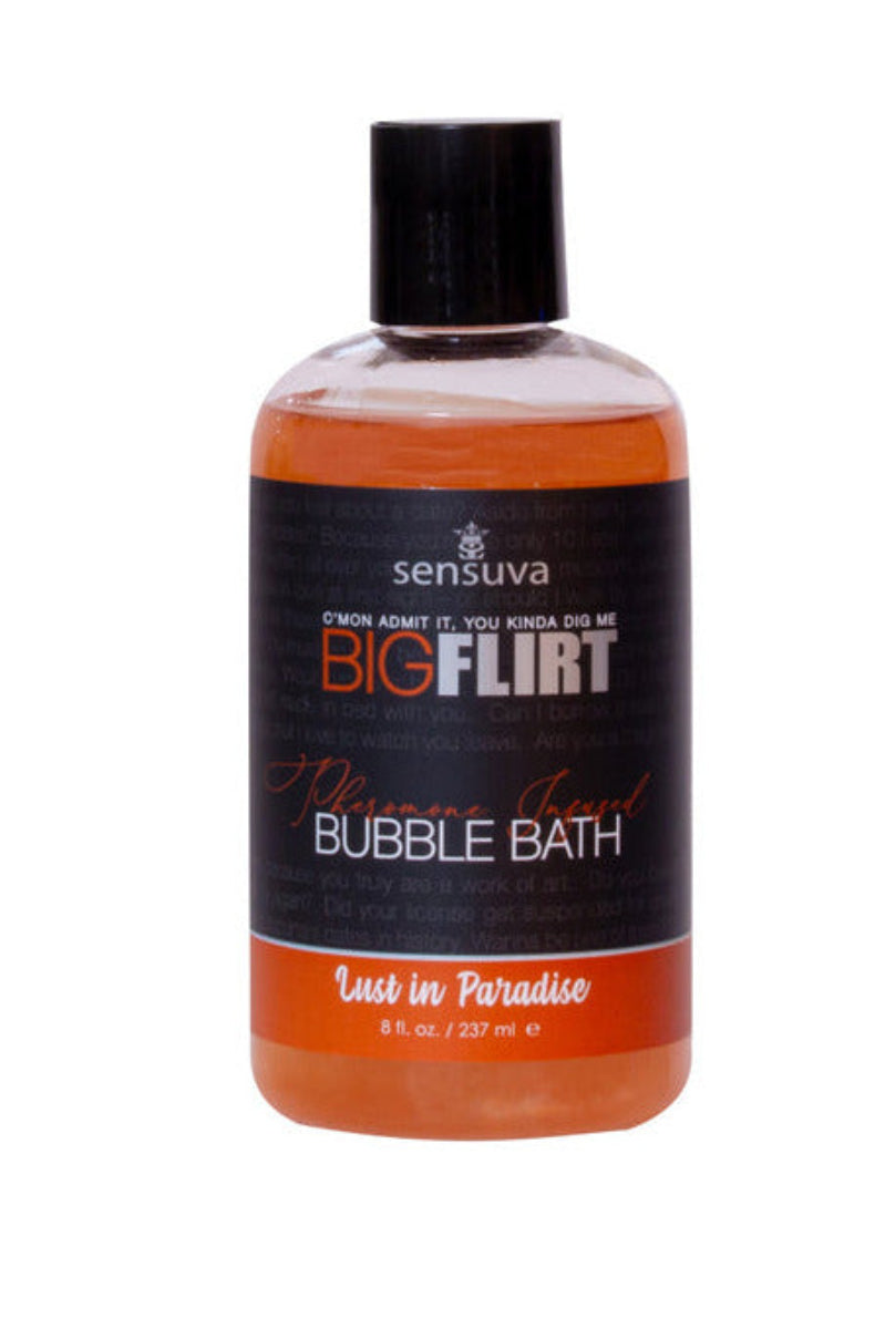 Sensuva Big Flirt pheromone bubble bath in Lust in Paradise, orange liquid in a clear 8 oz bottle with a pickup-line label.
