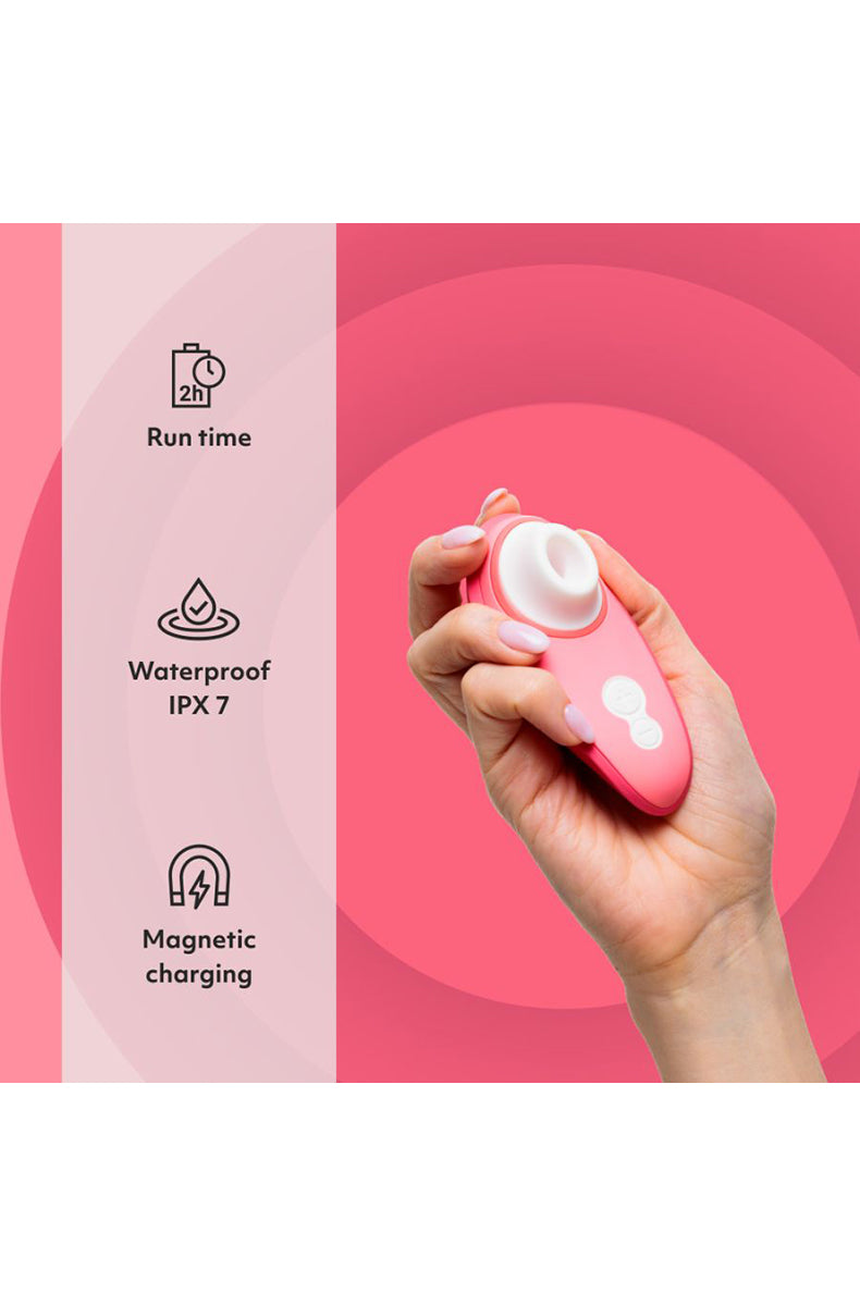 Vibrant rose Womanizer Liberty 2 with USB magnetic charging cable attached to the base.