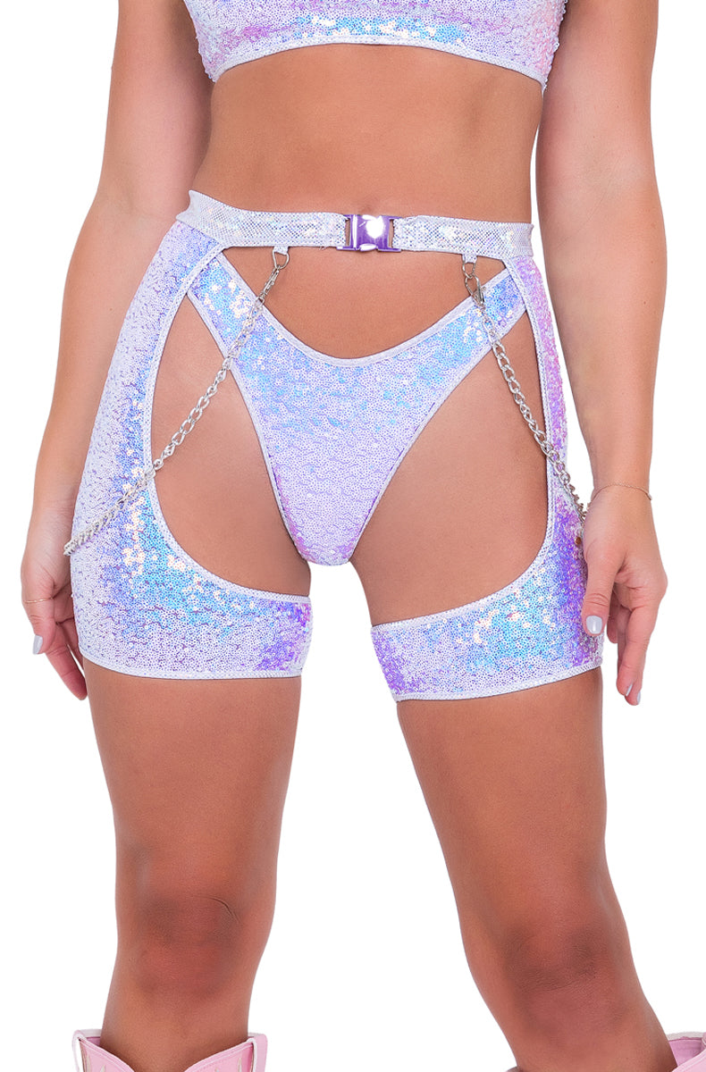 Model wearing lavender iridescent sequin chaps with buckle waistband and chain detail between the legs