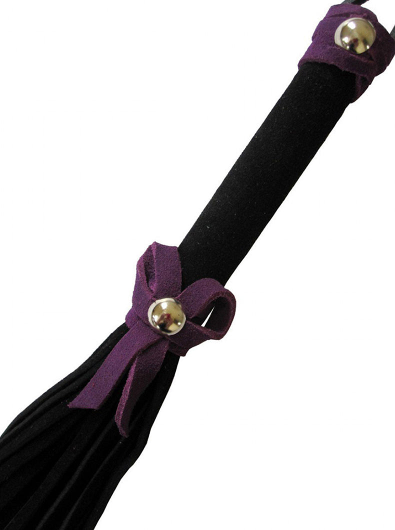 Close-up of the black suede handle with a purple suede bow and silver stud joining the falls below a top bow.