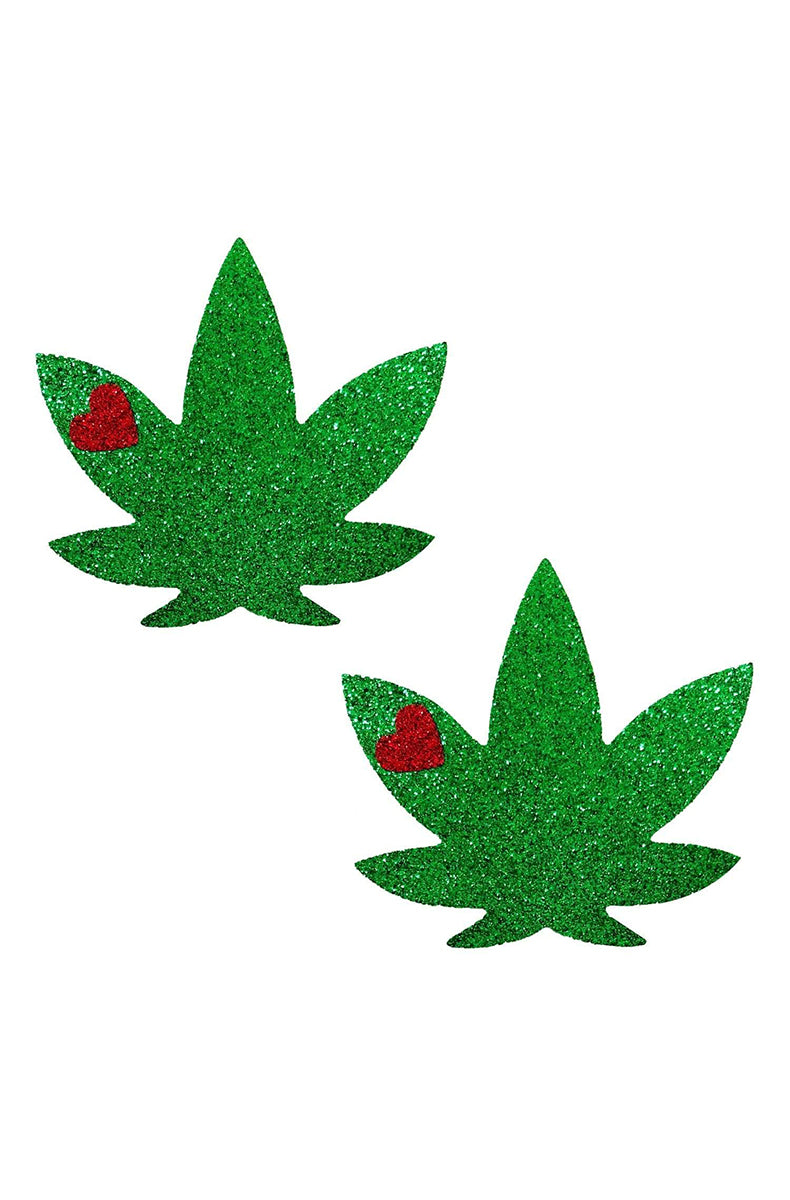 Two cannabis-leaf-shaped pasties in emerald green glitter with a small red heart on one upper leaflet of each.