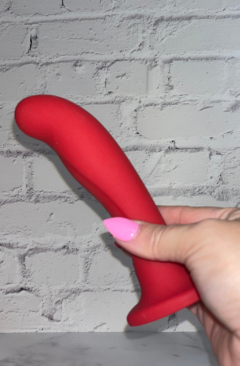 Side view of Blush Jezebel slim red silicone dildo showing upward curve angled for G-spot or prostate.