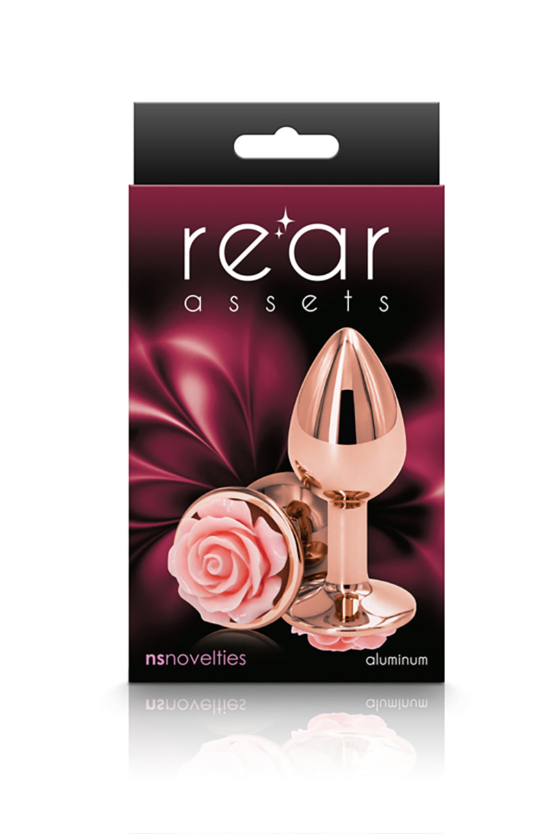 Rose gold floral butt plug on its side next to a standing plug, both showing the pink rose base.