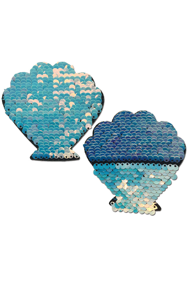 Two scallop-shell-shaped flip-sequin pasties: iridescent baby blue with hot-pink and ultraviolet shifts on one side, royal blue on the reverse.