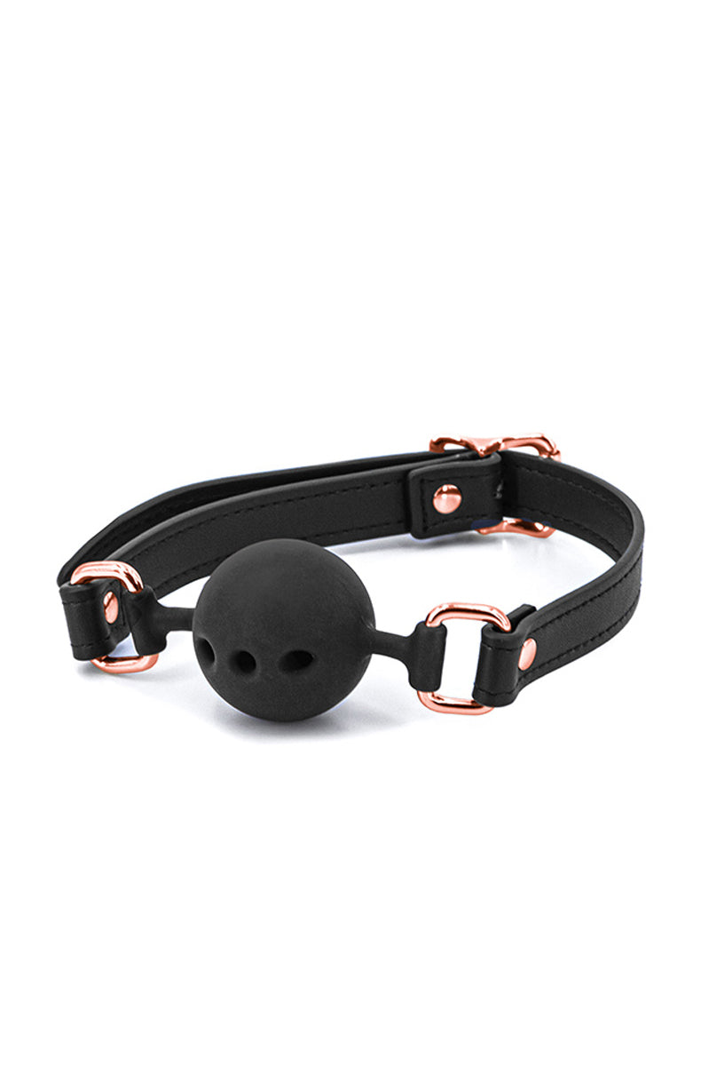 Black breathable silicone ball gag with three breathing holes on a black PU strap with rose-gold buckle, D-rings, and rivets.