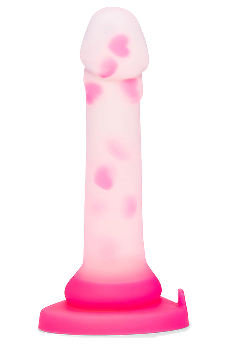 Clear silicone dildo with floating pink hearts standing on its pink suction cup base, front view