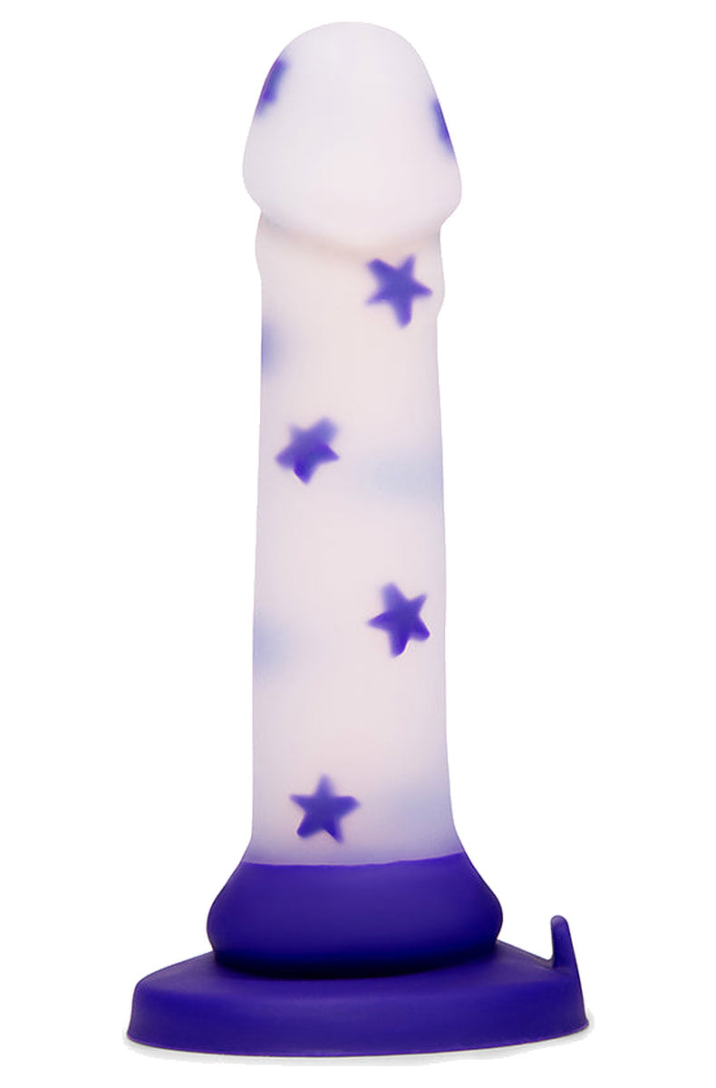 Clear silicone dildo with floating purple stars standing on its purple suction cup base, front view