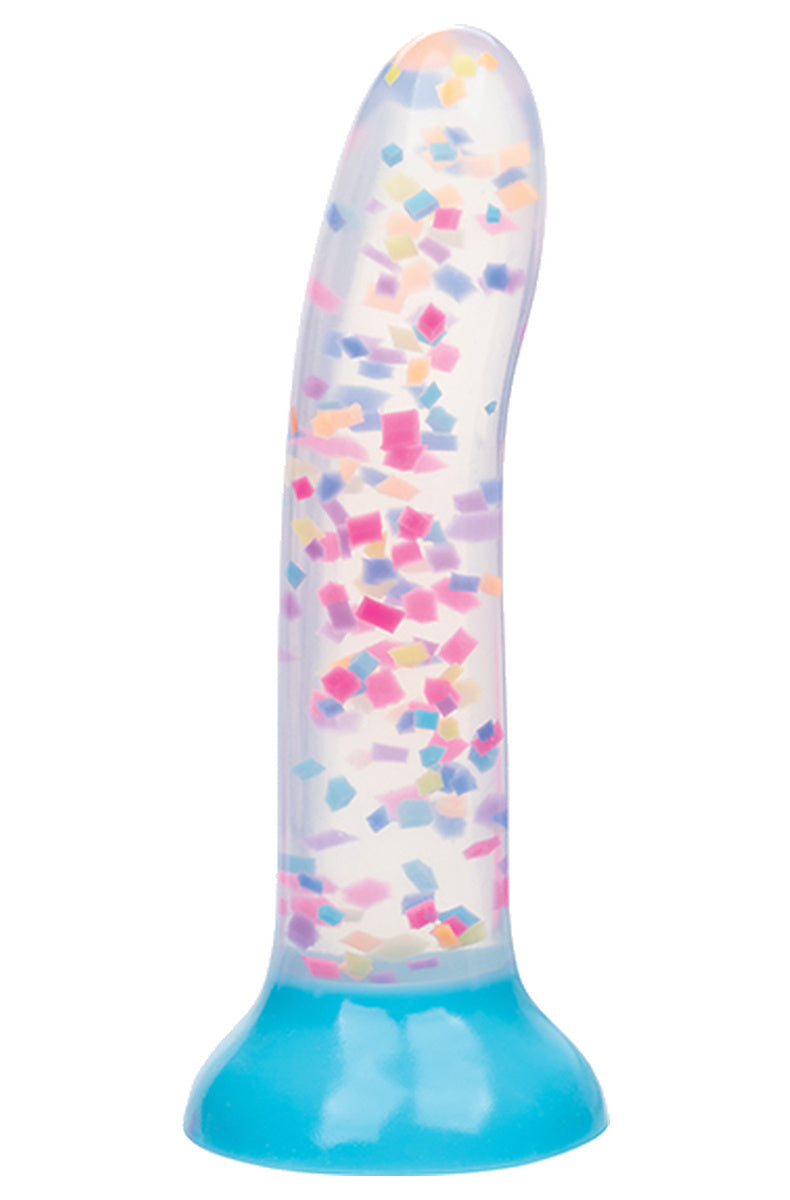 Clear dildo filled with rainbow confetti standing on its bright blue suction cup