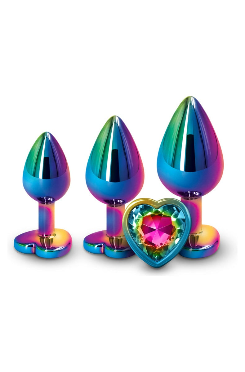 Three iridescent rainbow metal butt plugs in small, medium and large, one turned to show the pink heart gem in its heart shaped base