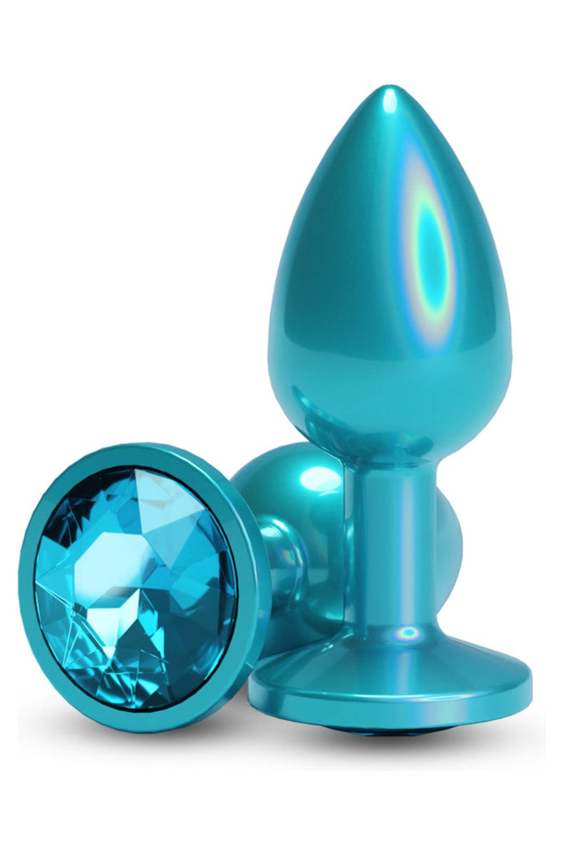 Teal metal butt plug standing upright next to a second plug lying flat, round teal gem set in the flared base
