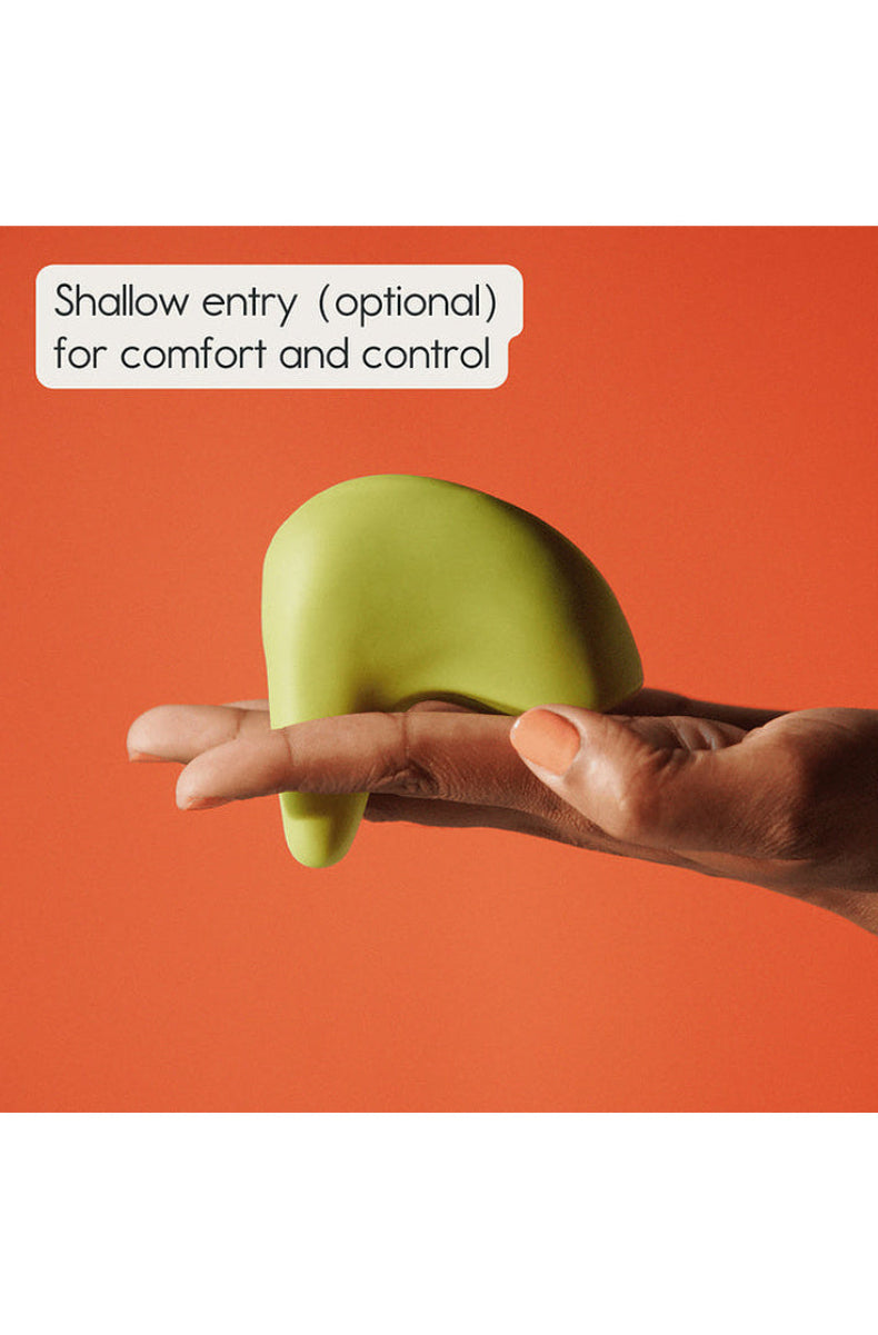 Green Kiwi massager held in a hand, showing the tapered end used for optional 1.5 inch shallow entry.