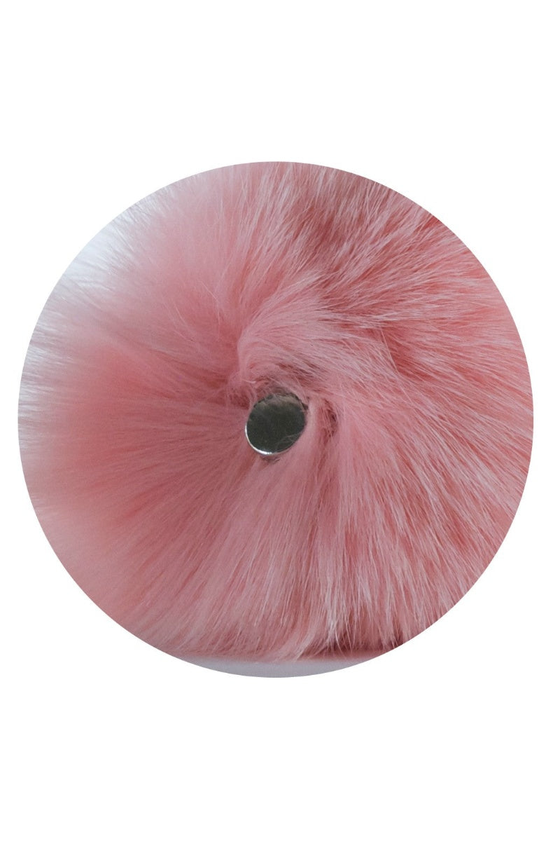 Close view of the pink pom bunny tail showing the round magnet at its center