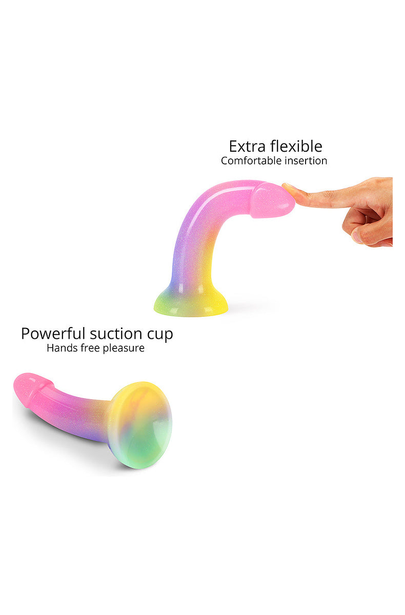 Rainbow glitter dildo bending under a fingertip to show flexibility, and its powerful suction cup base
