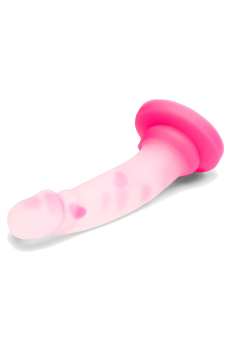 Frosted clear dildo with pink hearts lying on its side with the pink suction base raised