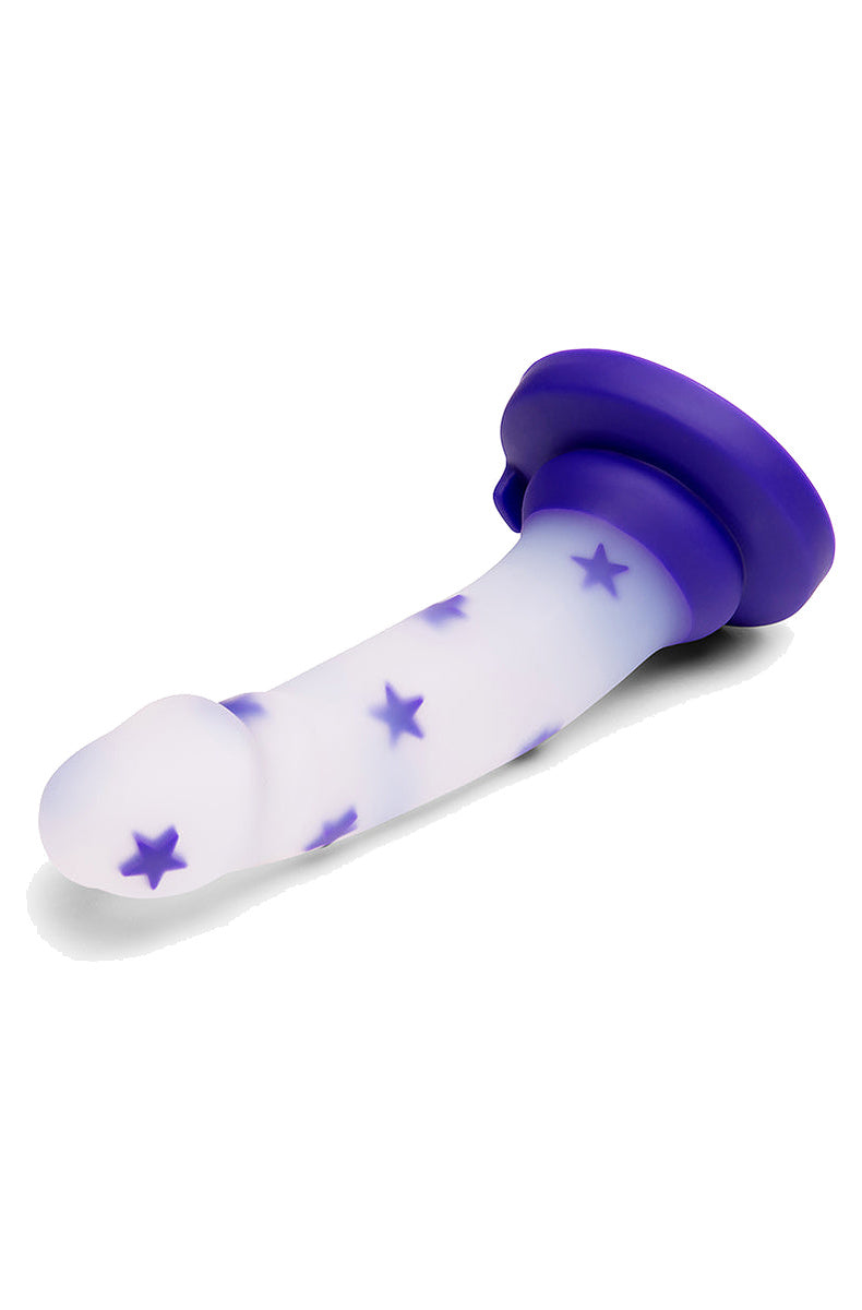 Frosted clear dildo with purple stars lying on its side with the purple suction base raised