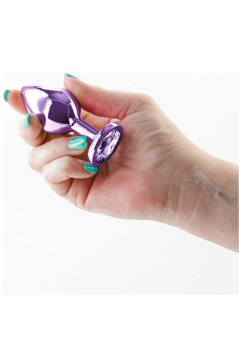 Medium purple metal butt plug held in a hand for scale, longer and wider than the small
