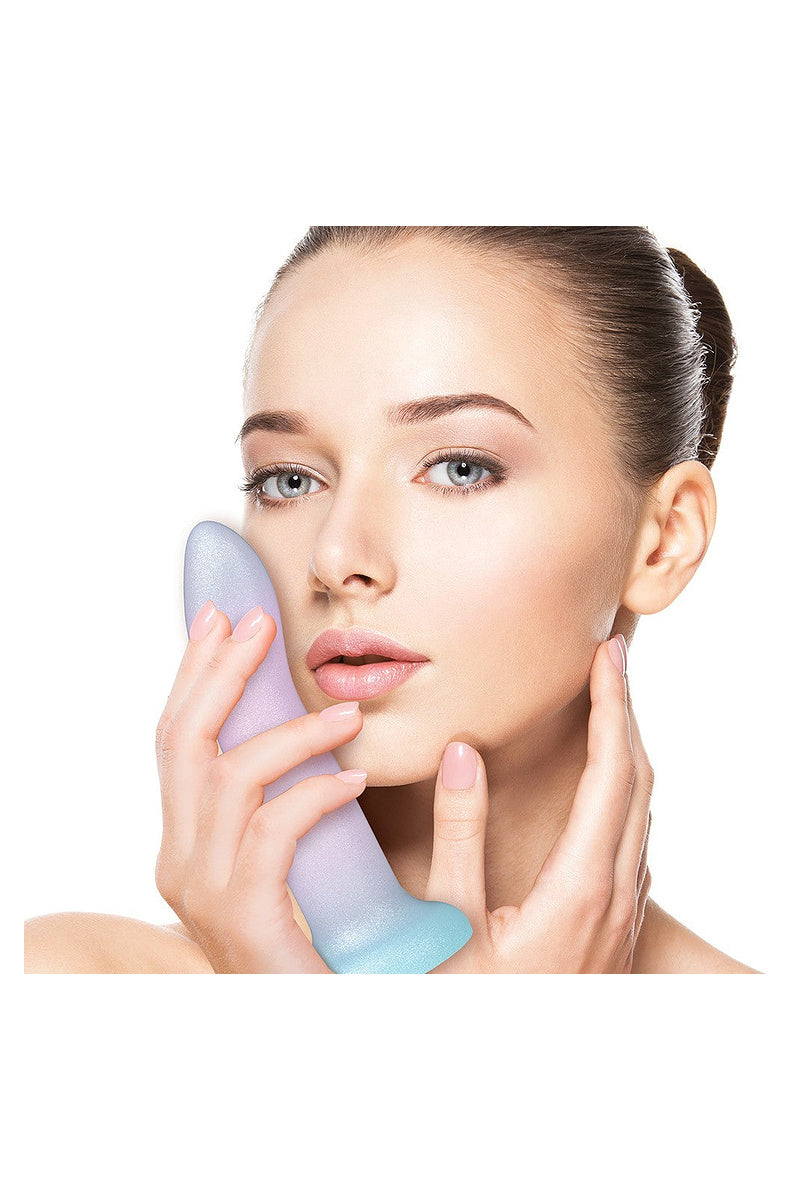 Model holding the lavender, pink and aqua ombre silicone dildo against her cheek