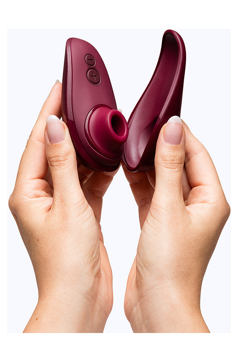 Hands opening the burgundy Womanizer Liberty 2 from its magnetic cover