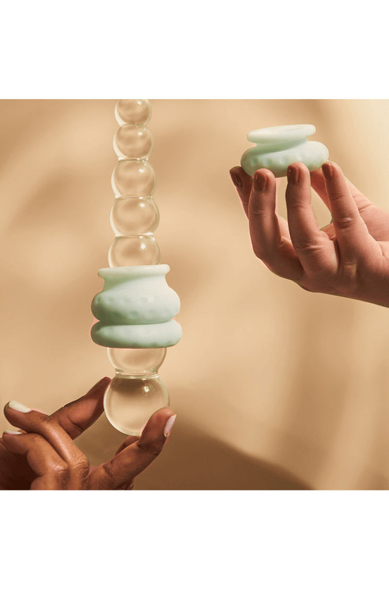 Ohnut rings stacked onto a clear glass toy, showing they work with toys as well as partners.