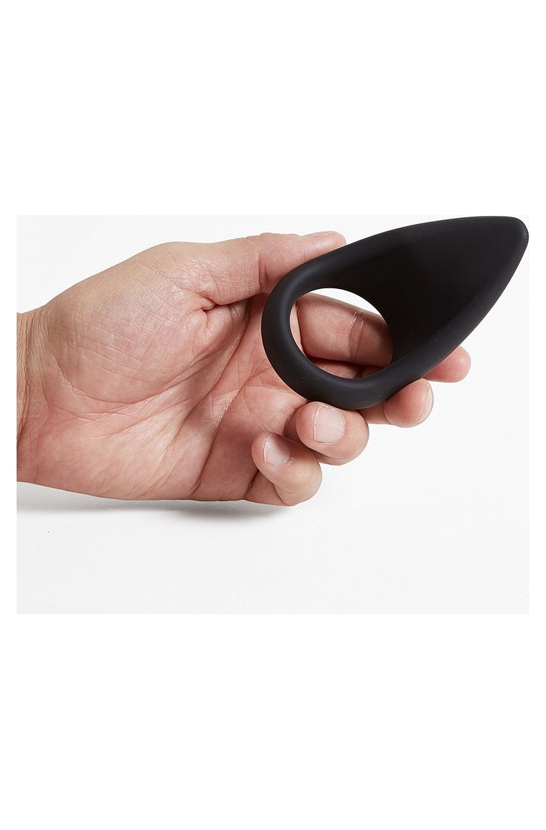 Tantus C-Sling held in a hand for scale, with a finger through the ring opening