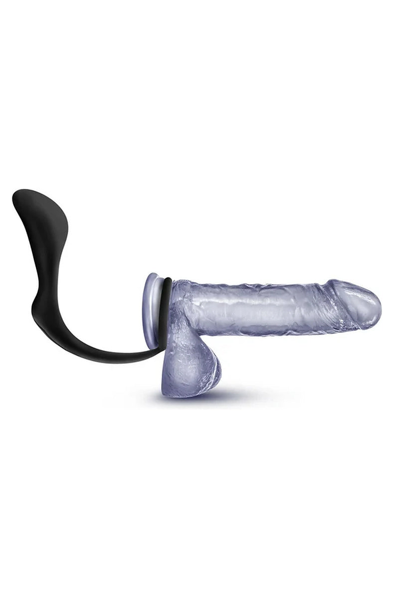 Anal Adventures Platinum cock ring plug fitted on a clear model, ring around the shaft and balls with the plug positioned behind