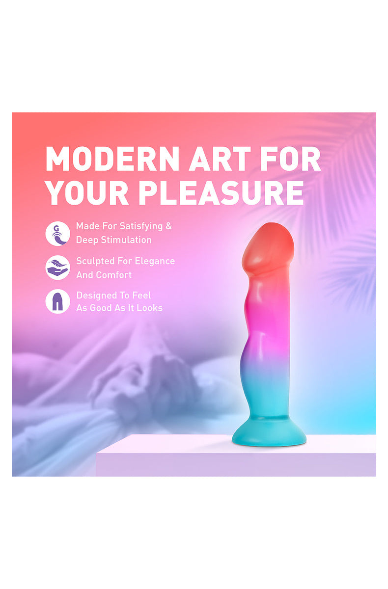 Coral, pink and aqua ombre dildo on a bed: made for satisfying deep stimulation, sculpted for elegance and comfort