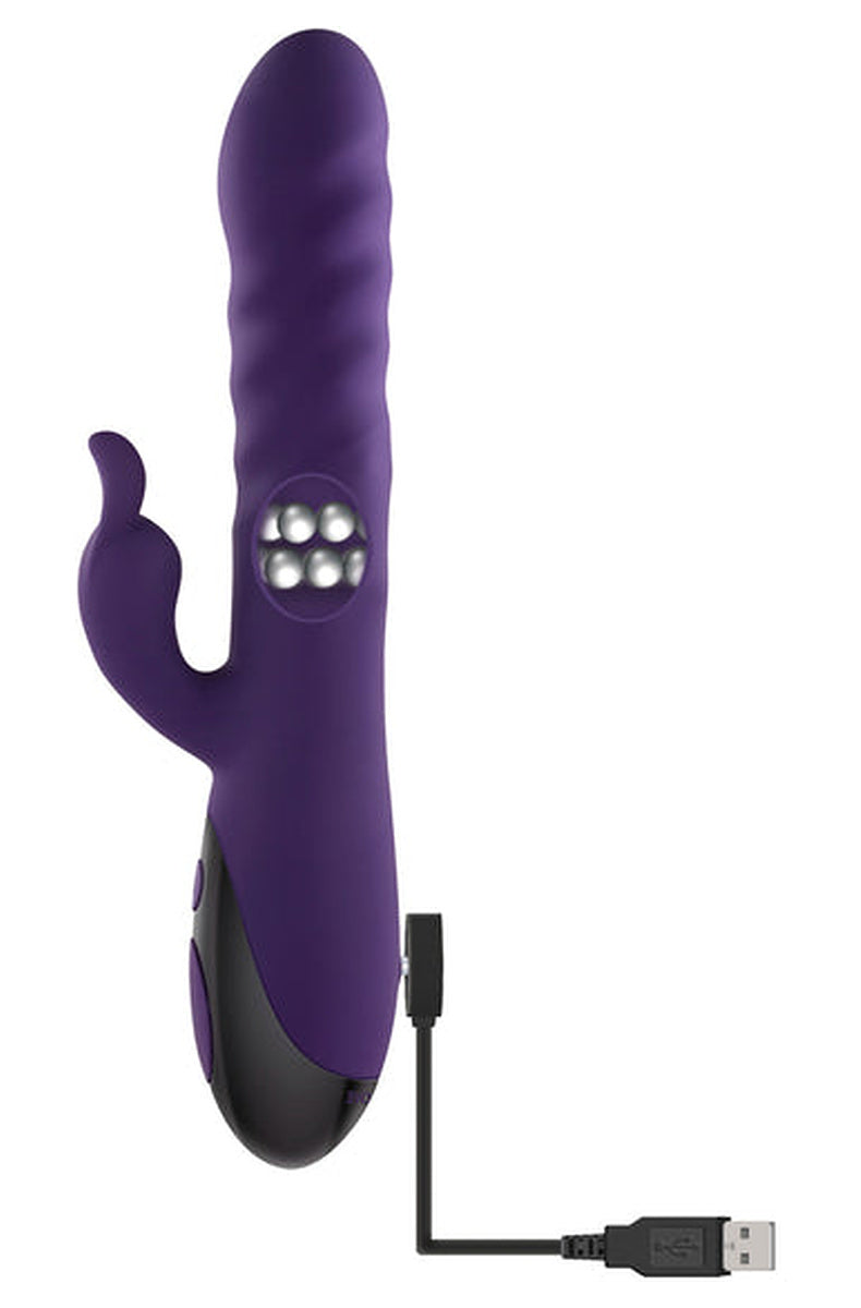 Purple Rascally Rabbit vibrator with the included magnetic USB charging cable attached to the base.