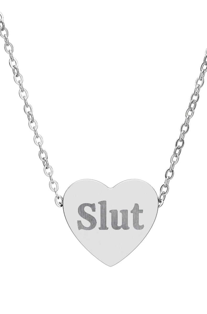 Heart-shaped pendant with 'Slut' engraved on a silver chain against a white background
