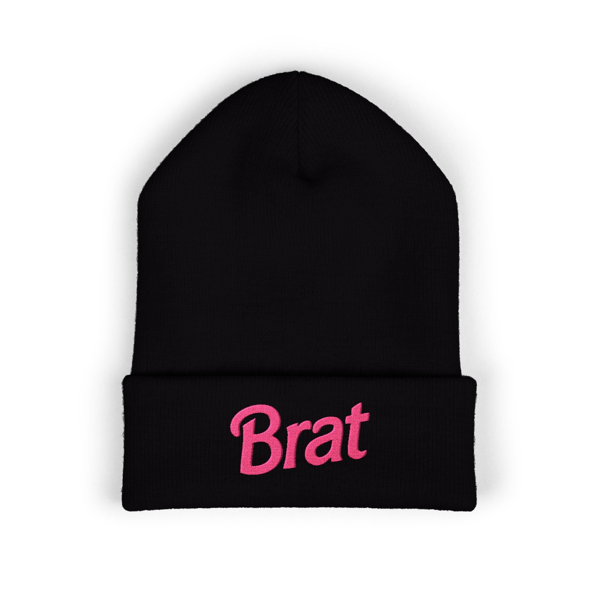 Soft pastel pink cuffed knit beanie with bold hot-pink "Brat" embroidery across the front of the cuff, worn by a model with pink hair.