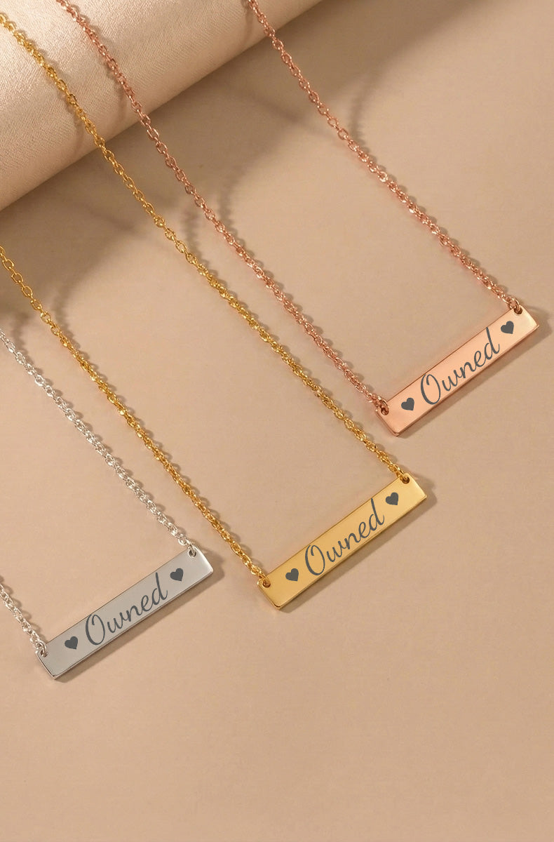 Three horizontal bar necklaces with "Owned" text in silver, gold, and rose gold finishes on matching chains