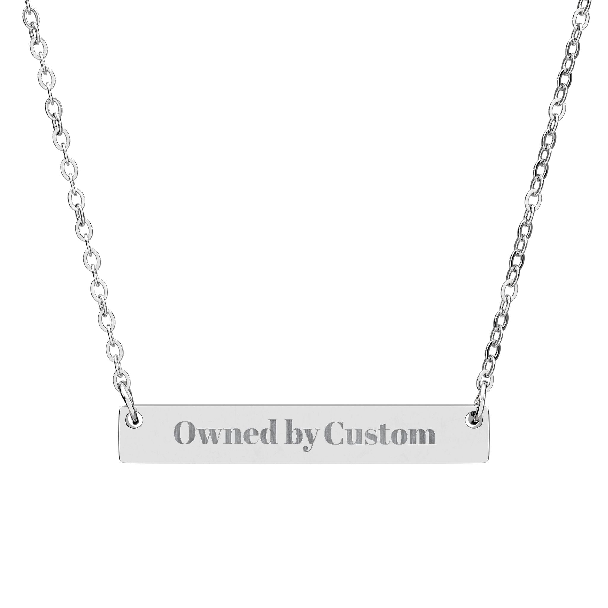 Silver necklace with a bar pendant engraved 'owned by custom' on a white background