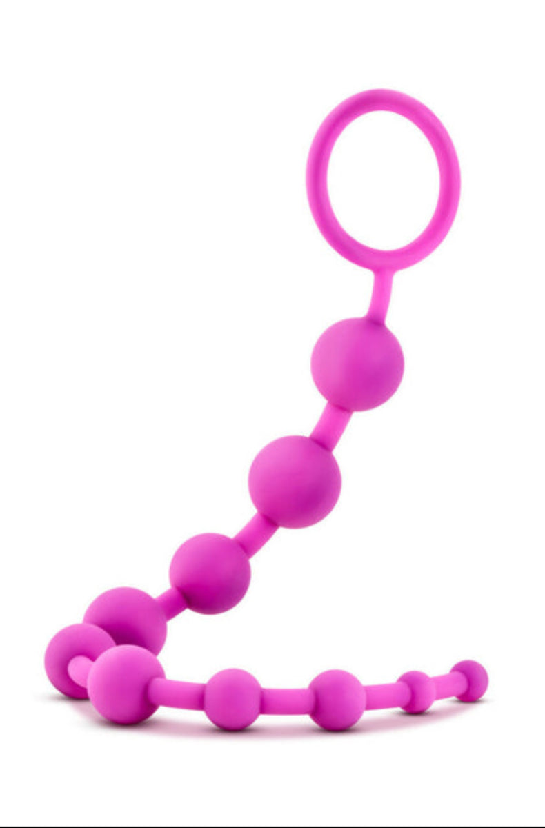 Pink silicone anal beads, ten graduated beads with a looped ring handle at top right, on a white background.