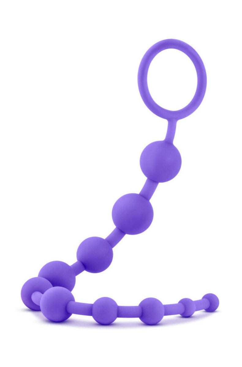 Purple silicone anal beads, ten graduated beads with a looped ring handle at top right, on a white background.