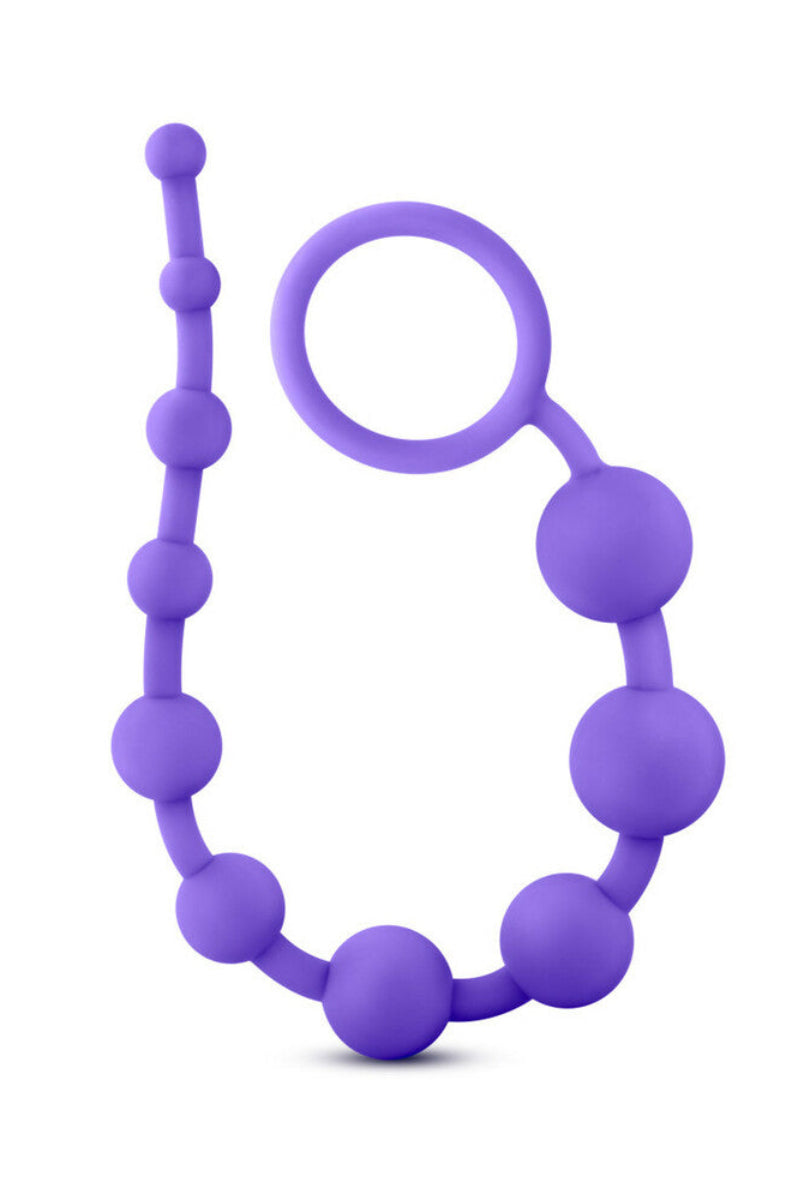 Purple silicone anal beads coiled upright with the looped ring handle near the top, on a white background.