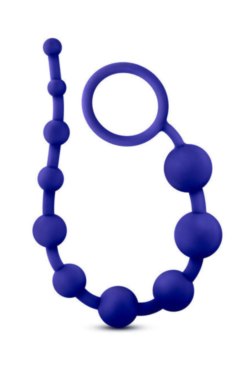 Indigo silicone anal beads coiled upright with the looped ring handle near the top, on a white background.