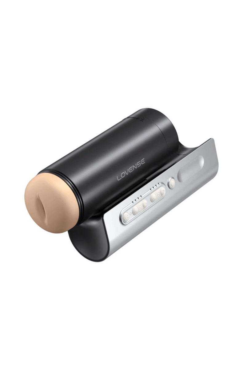 Front view of black cylindrical masturbator with flesh-toned opening in silver charging dock with control buttons