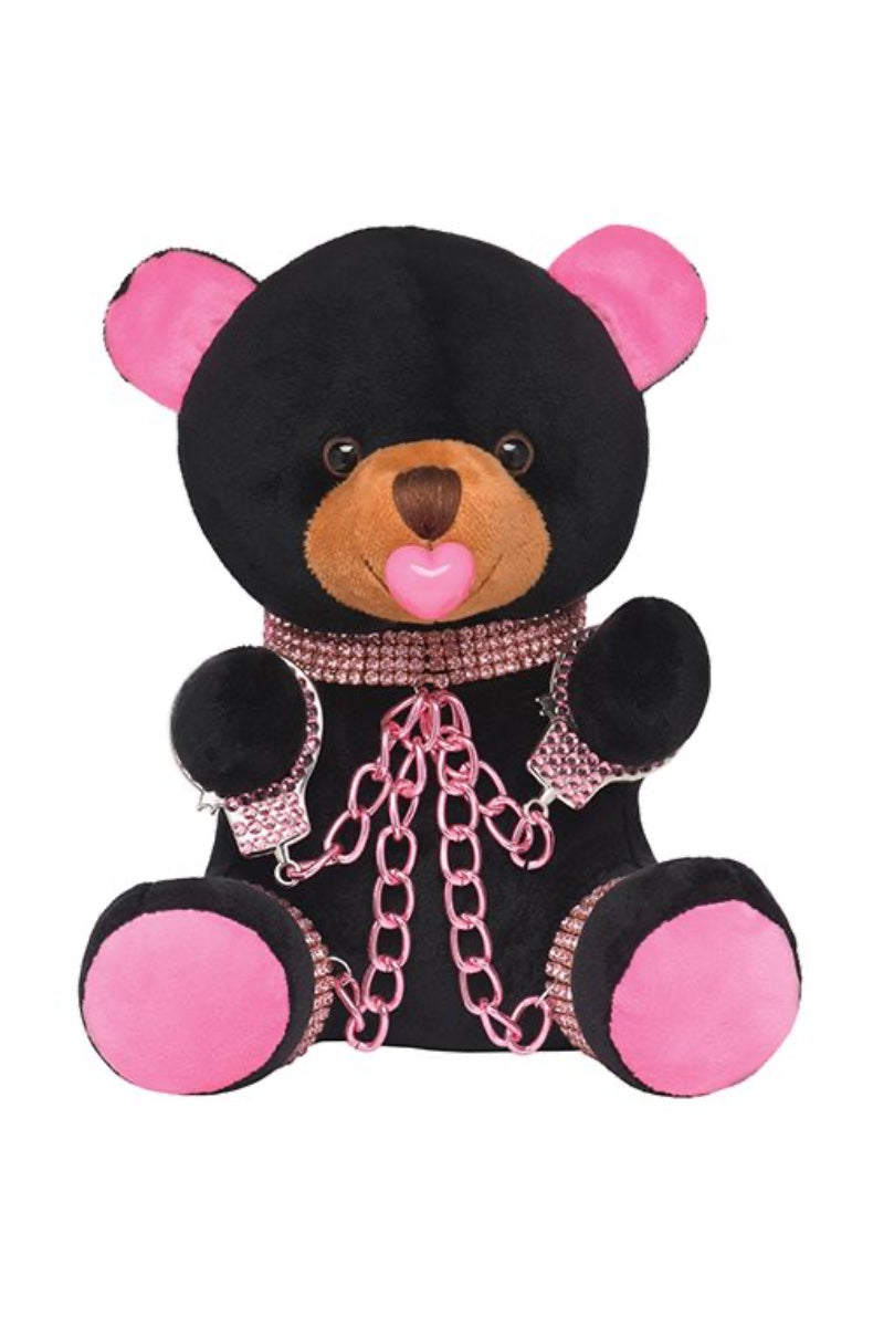 Front view of black plush teddy bear with pink ears, rhinestone collar and cuffs, pink chains, and heart pacifier in mouth