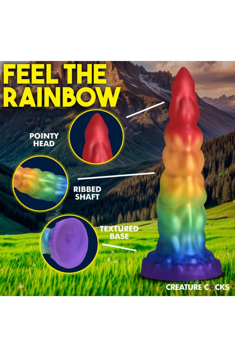 Rainbow unicorn horn dildo shown on mountain landscape with callouts highlighting pointy head, ribbed shaft, and textured base features