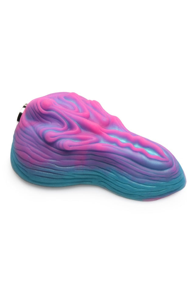 Three-quarter view of pink-purple-teal gradient silicone grinder showing curved organic shape on white background