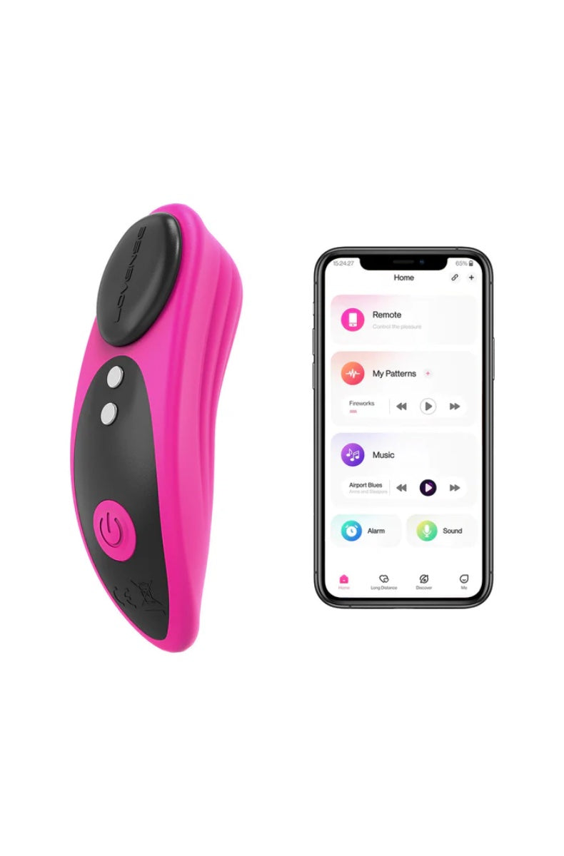 Pink panty vibrator with black magnetic cap next to smartphone displaying Lovense app interface