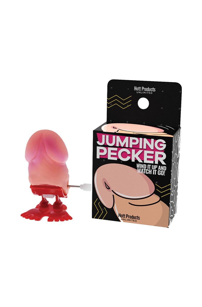 Side view of pink wind-up plastic penis-shaped toy showing the turn key and palm-sized body.