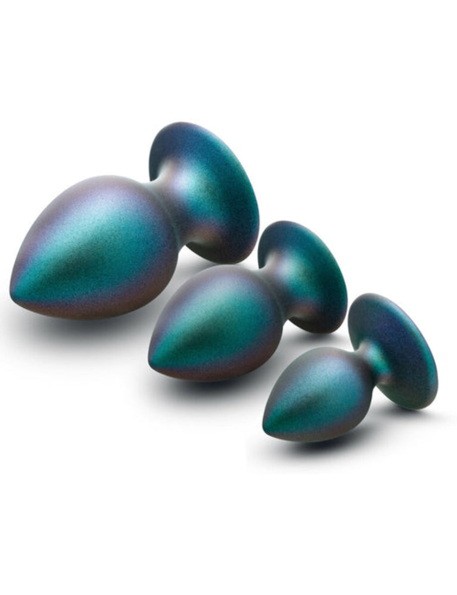 Three iridescent teal anal plugs lying at an angle, large to small, showing the shimmer finish and flared bases.