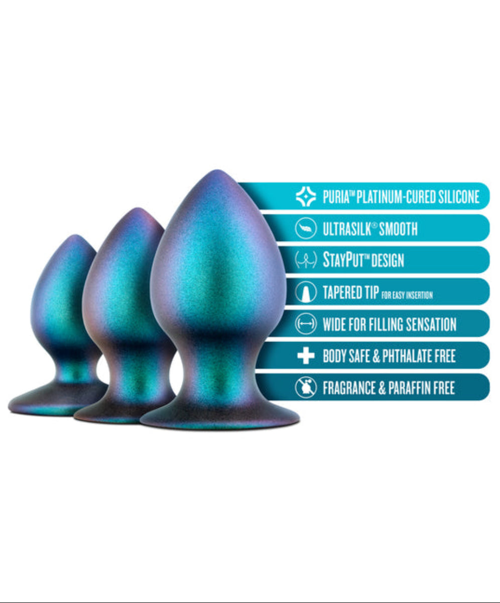 Iridescent teal anal plug trio beside labels: Puria platinum-cured silicone, UltraSilk, StayPut, tapered tip, body safe.