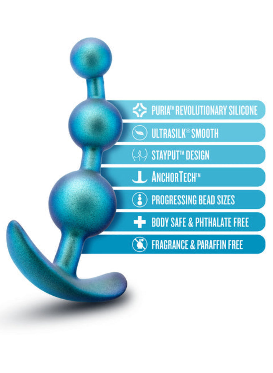 Teal silicone anal plug beside labels: Puria silicone, UltraSilk smooth, StayPut, AnchorTech, body safe, phthalate free.