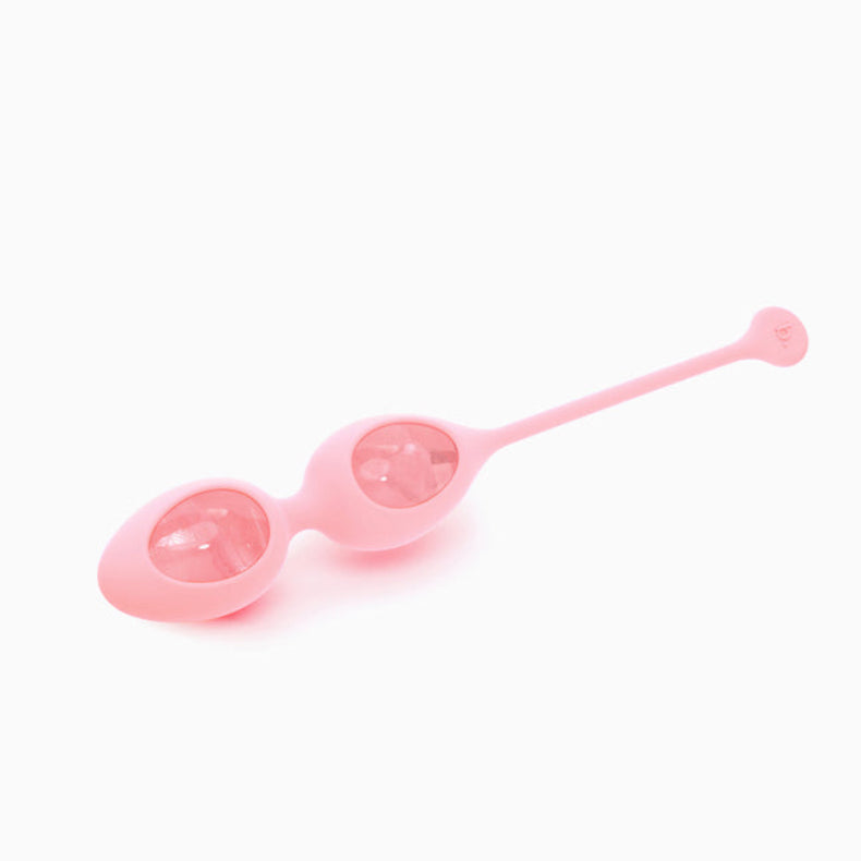 Double rose quartz egg holder in pink silicone with two eggs visible through windows and a long retrieval stem, on white.