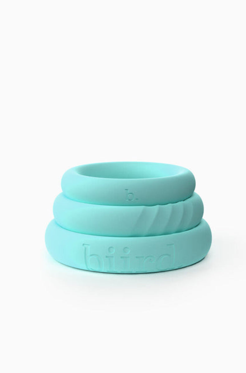 Three stacked mint silicone cock rings in small, medium, and large, smooth and ribbed bands, on white.