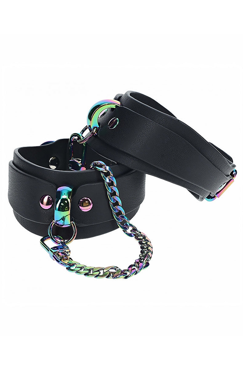 Pair of wide black bonded leather ankle cuffs with iridescent rainbow metal D-rings and a connecting chain.
